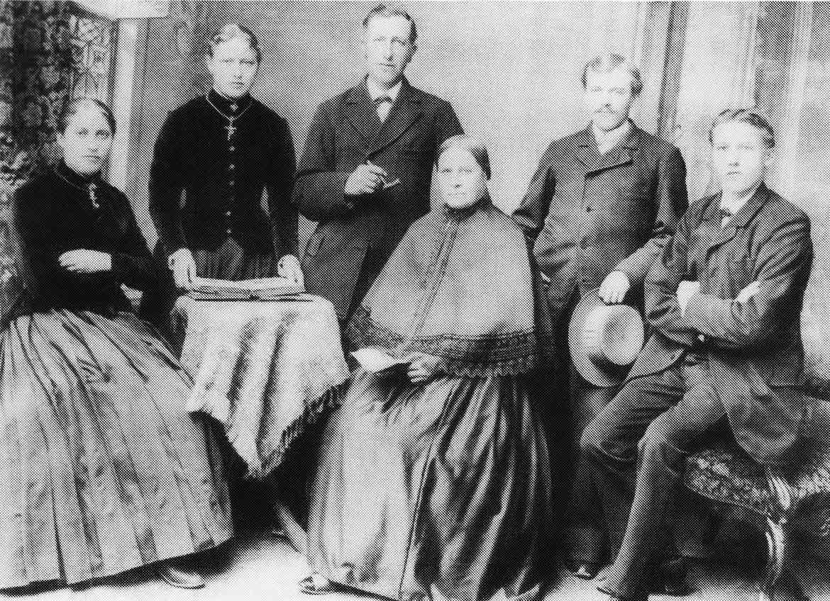 historisches Gruppenfoto von drei Frauen und Männern.